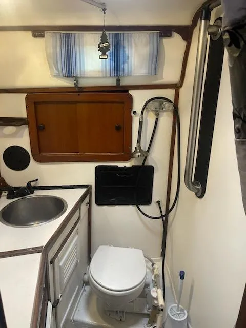 Slide: The Image of Compact bathroom in 1981 Allied Mistress Mk III sailboat with sink, toilet, and storage. - 8