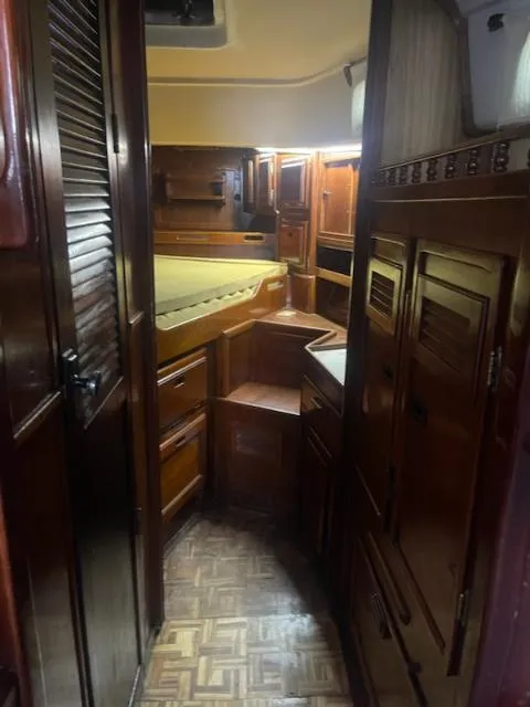 Slide: The Image of 1981 Allied Mistress Mk III yacht interior with wooden cabinetry and cozy sleeping area. - 9