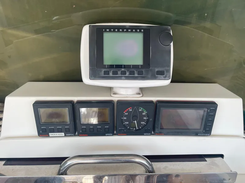 Slide: The Image of 1995 Passport 47 AC Plan B boat dashboard with navigation and control instruments. - 12