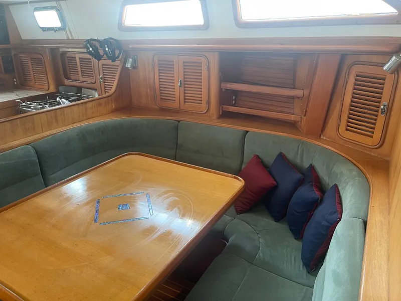 Slide: The Image of Interior of 1995 Passport 47 AC Plan B sailboat with dining area and wooden cabinetry. - 26