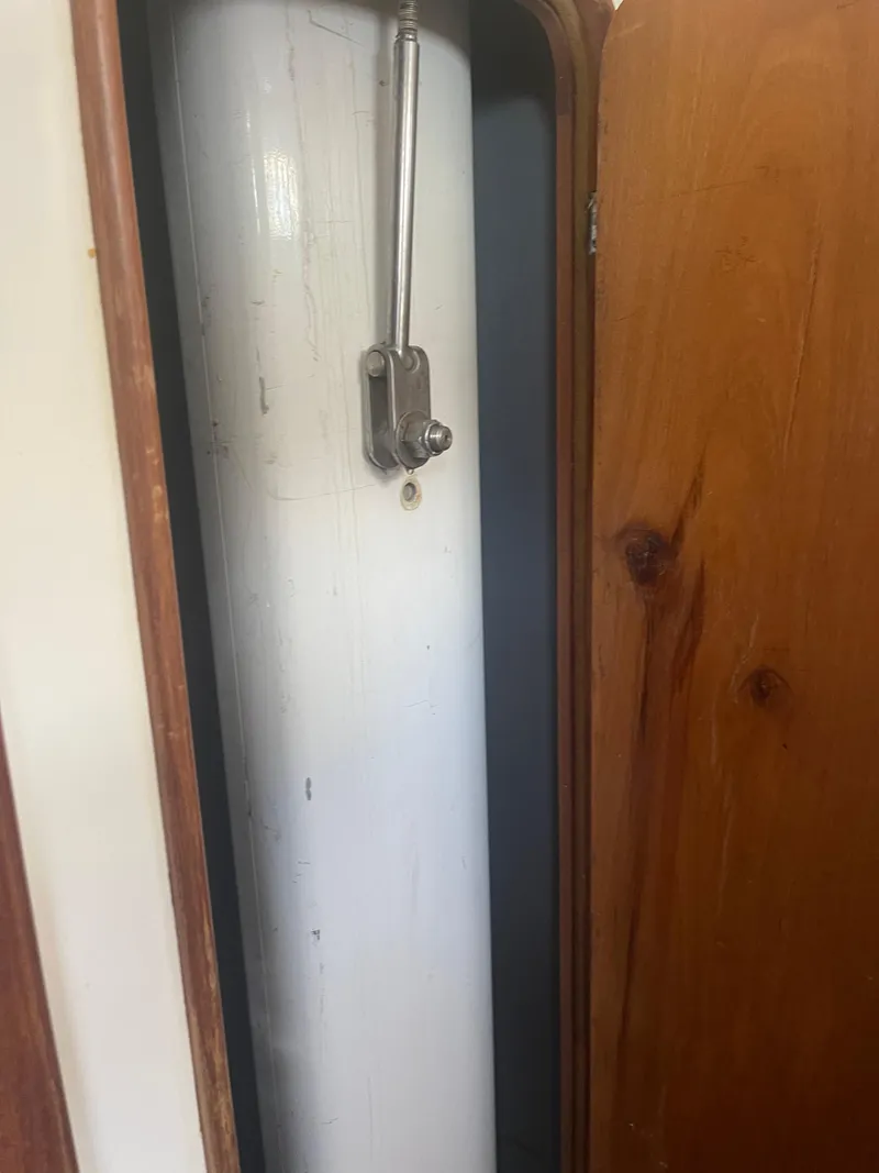 Slide: The Image of Close-up of a 1995 Passport 47 AC Plan B sailboat mast inside a wooden compartment. - 34