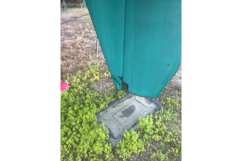 Slide: The Image of Damaged keel of 1995 Passport 47 AC Plan B sailboat on grassy ground. - 46