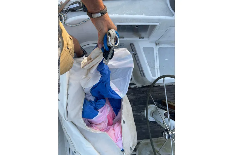 Slide: The Image of Person handling colorful sail on 1995 Passport 47 AC Plan B yacht deck. - 52