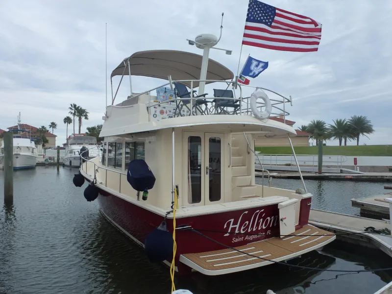 Slide: The Image of 2005 Mainship 34 Trawler docked, named Hellion, with American flag. - 1