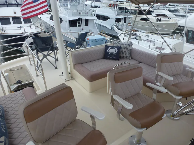 Slide: The Image of Mainship 34 Trawler 2005 boat deck with seating and American flag in marina. - 10