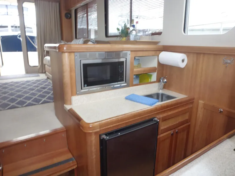 Slide: The Image of Mainship 34 Trawler 2005 interior kitchen with microwave, sink, and mini-fridge. - 25
