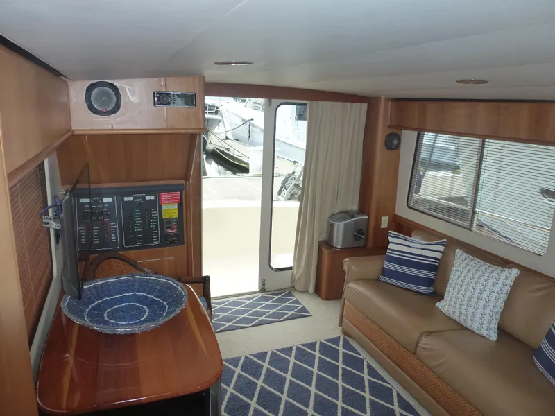 Slide: The Image of Interior of 2005 Mainship 34 Trawler with sofa, TV, and nautical decor. - 29