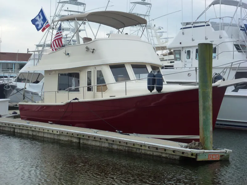 Slide: The Image of 2005 Mainship 34 Trawler docked at marina with flags. - 3