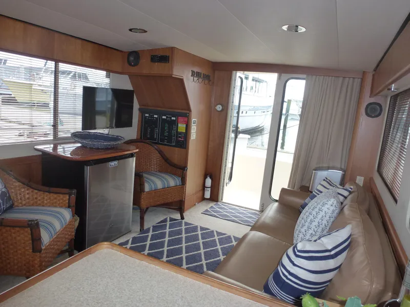 Slide: The Image of Interior of 2005 Mainship 34 Trawler with seating, mini-fridge, and nautical decor. - 30