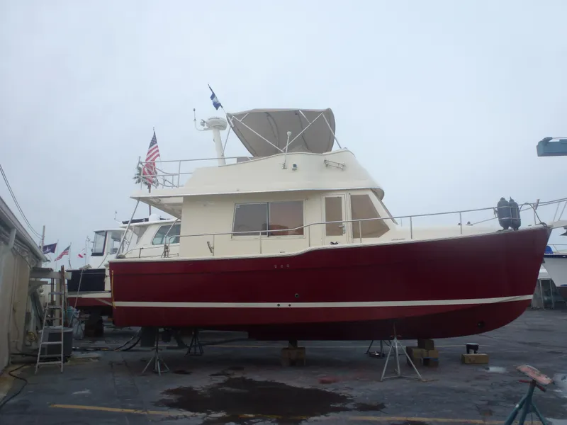 Slide: The Image of 2005 Mainship 34 Trawler with red hull on dry dock. - 35