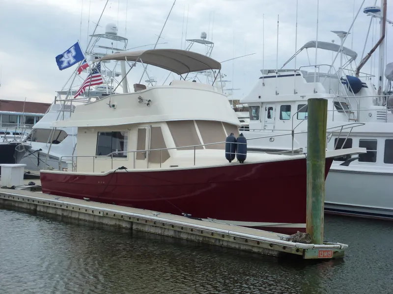 Slide: The Image of 2005 Mainship 34 Trawler docked at marina with flags. - 5