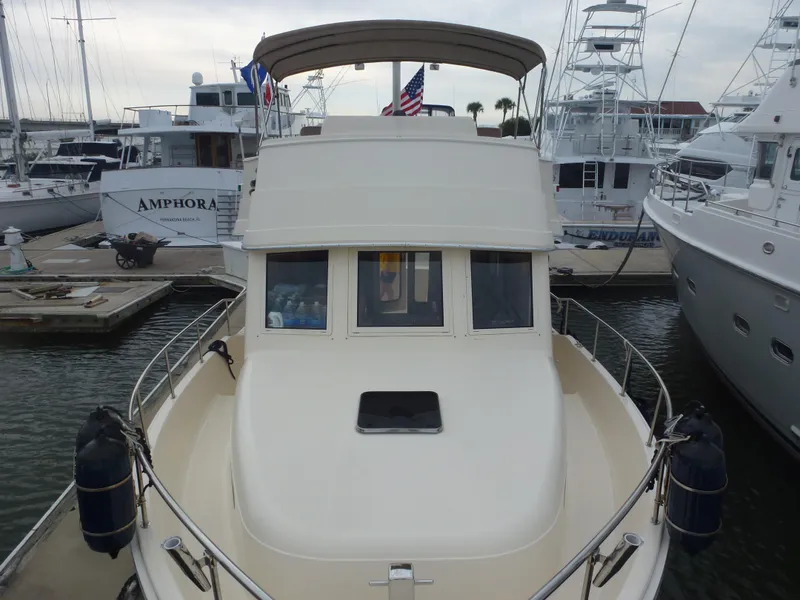 Slide: The Image of 2005 Mainship 34 Trawler docked at a marina, front view. - 6