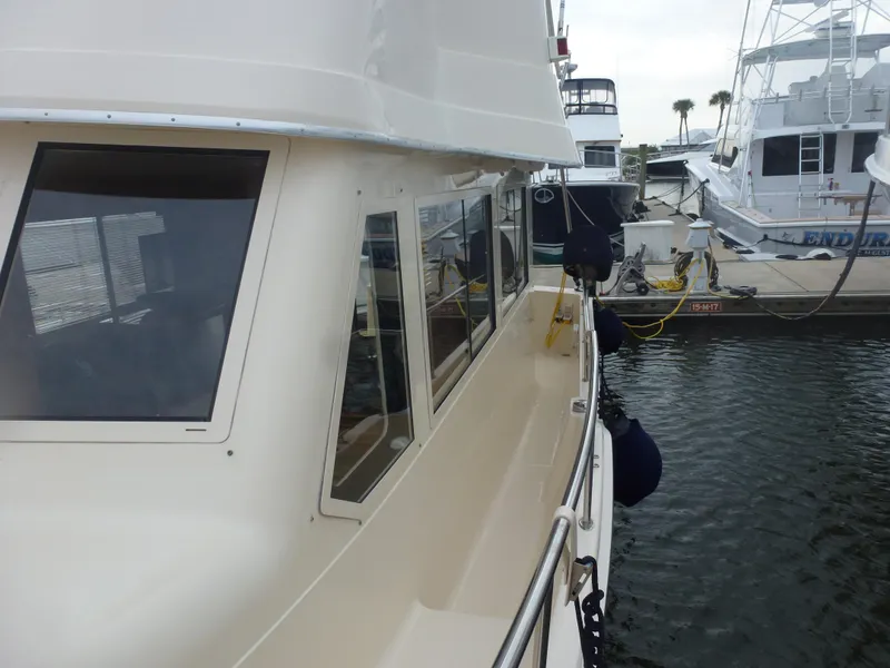 Slide: The Image of 2005 Mainship 34 Trawler docked at a marina, side view. - 7