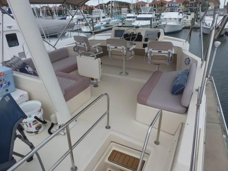 Slide: The Image of 2005 Mainship 34 Trawler flybridge with seating and helm station in marina. - 8