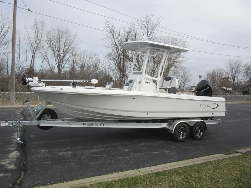 The Image of 2024 Robalo 226 Cayman boat on a trailer in a parking lot. - 0