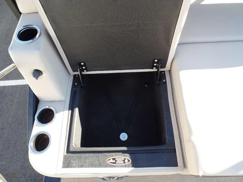 Slide: The Image of 2024 Harris Cruiser 250 storage compartment with cup holders and cushioned seating. - 5