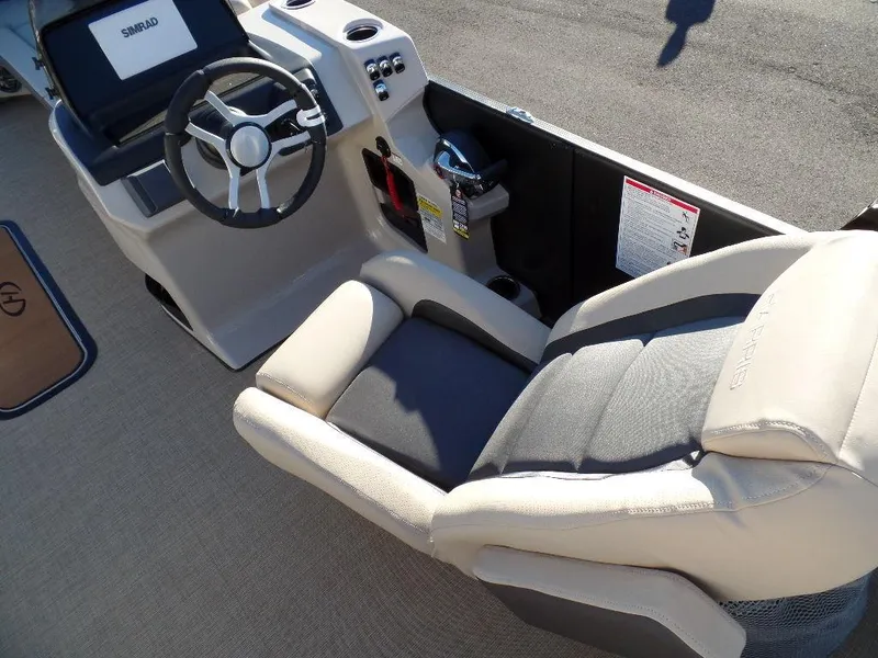 Slide: The Image of 2024 Harris Cruiser 250 boat interior with steering wheel and comfortable seating. - 9