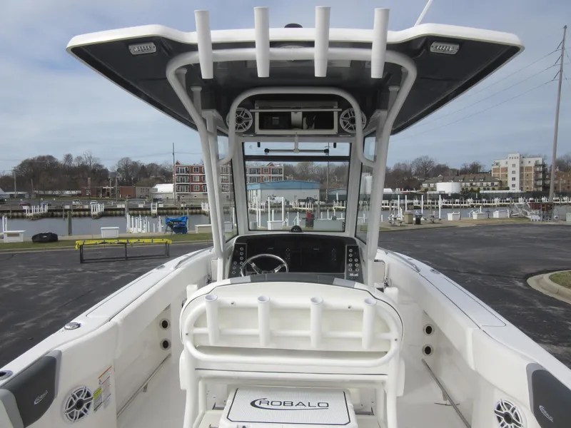 Slide: The Image of 2024 Robalo R250 Center Console boat at a marina, showcasing helm and seating. - 19