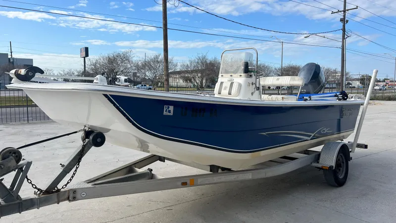 Slide: The Image of 2013 Carolina Skiff 198DLX boat on trailer, blue and white hull, parked outdoors. - 5