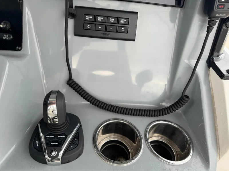 Slide: The Image of Cobia 301 CC 2021 boat console with joystick controls and cup holders. - 10