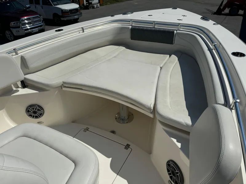 Slide: The Image of 2021 Cobia 301 CC boat interior with cushioned seating and speakers. - 13