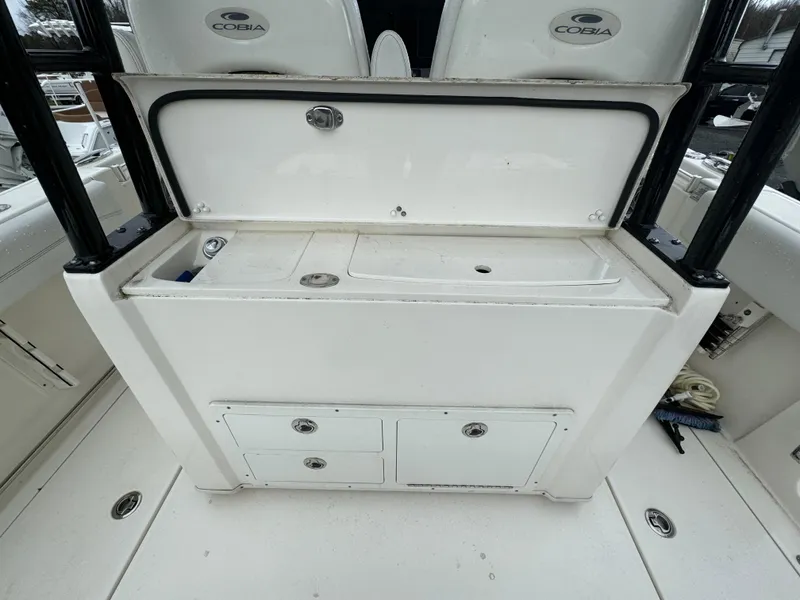 Slide: The Image of 2021 Cobia 301 CC boat interior with storage compartments and seating. - 15
