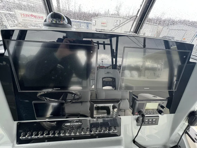 Slide: The Image of Dashboard of 2021 Cobia 301 CC boat with Garmin displays and controls. - 9