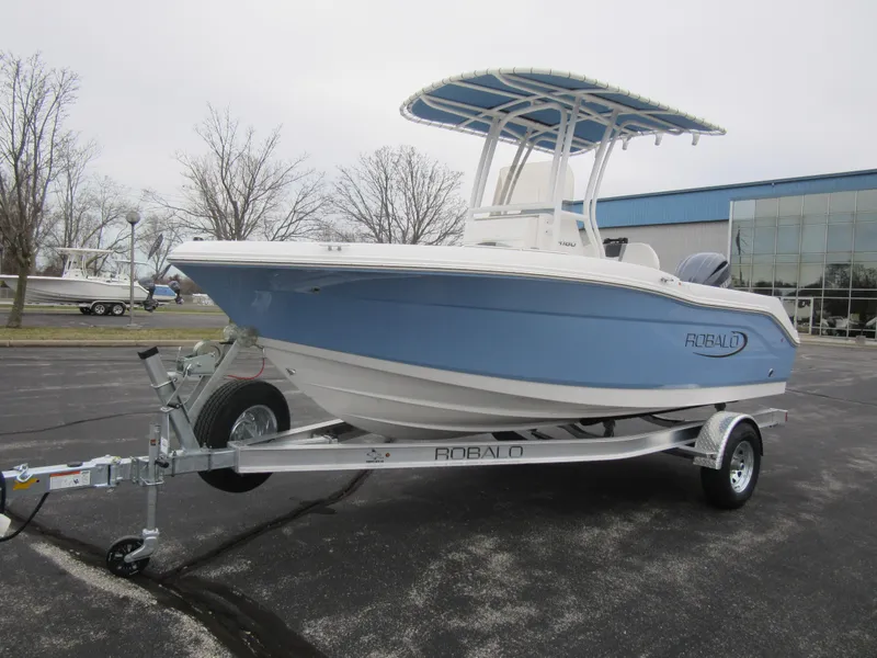 The Image of 2024 Robalo R180 Center Console boat on a trailer in a parking lot. - 0