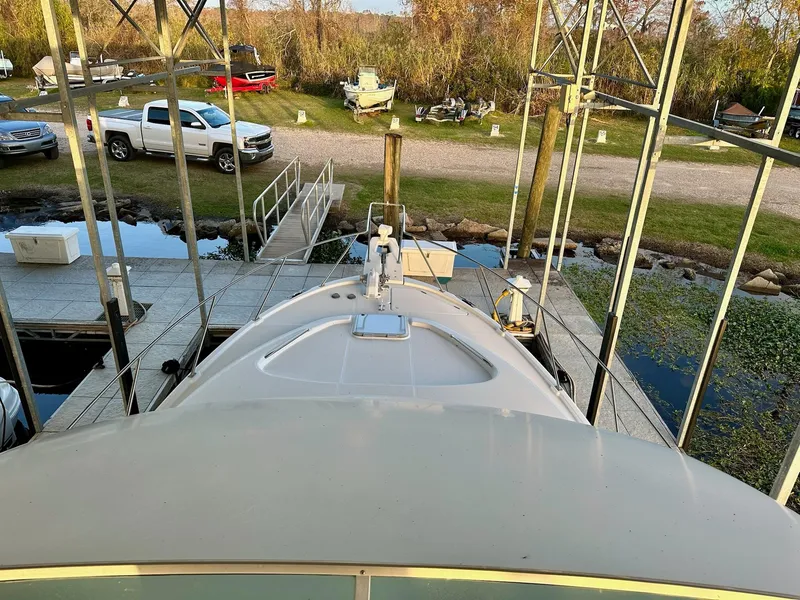 Slide: The Image of 1997 Bayliner 3988 Motoryacht docked, surrounded by vehicles and greenery. - 10