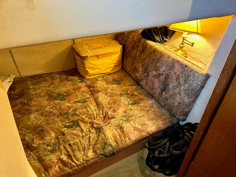 Slide: The Image of Cozy cabin interior of 1997 Bayliner 3988 Motoryacht with patterned bedding and warm lighting. - 14