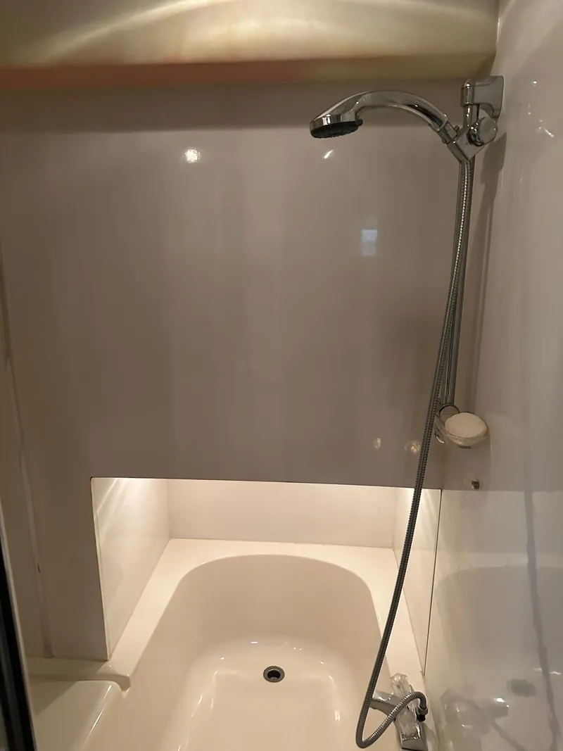 Slide: The Image of Shower area in 1997 Bayliner 3988 Motoryacht, featuring a handheld showerhead and bathtub. - 19