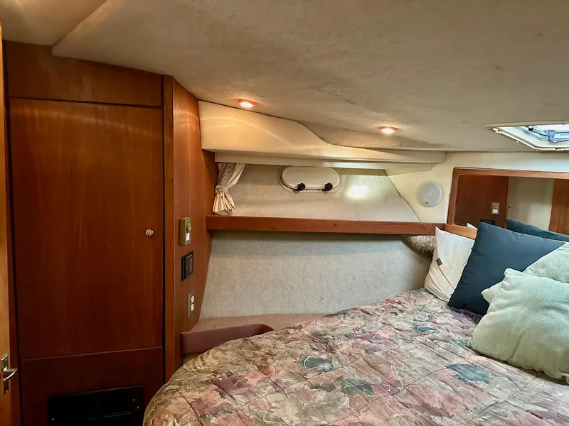 Slide: The Image of 1997 Bayliner 3988 Motoryacht cabin interior with cozy bed and wooden accents. - 29
