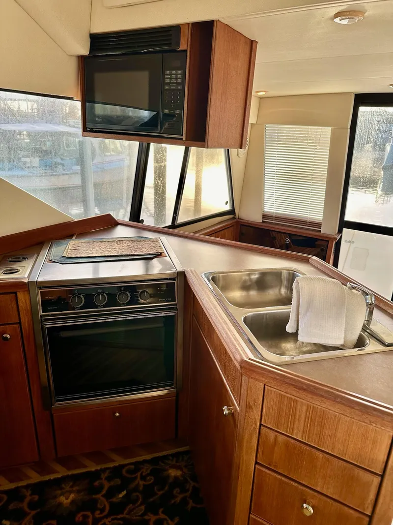 Slide: The Image of 1997 Bayliner 3988 Motoryacht kitchen with stove, sink, and microwave. - 32