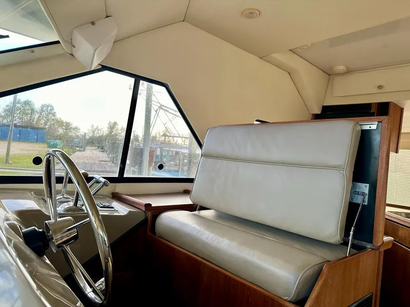 Slide: The Image of 1997 Bayliner 3988 Motoryacht interior with steering wheel and cushioned seating. - 34