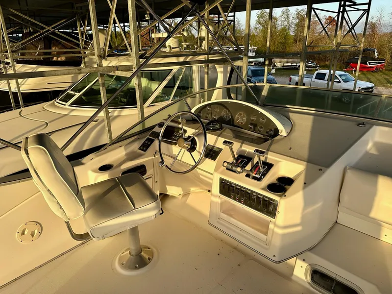 Slide: The Image of 1997 Bayliner 3988 Motoryacht helm with steering wheel and control panel in marina setting. - 9