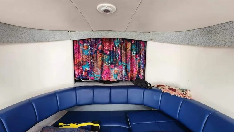 Slide: The Image of Interior of a 1996 Formula 382 SR1 boat with blue seating and colorful curtains. - 4