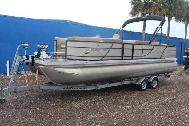 The Image of 2022 Veranda VF25F2 pontoon boat on trailer, parked outdoors near blue building. - 1