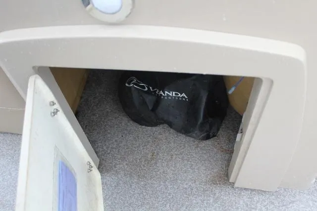 Slide: The Image of Open storage compartment on a 2022 Veranda VF25F2 boat, revealing a Veranda-branded bag inside. - 14