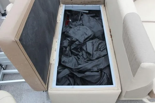 Slide: The Image of Open storage compartment in Veranda VF25F2 boat, revealing black fabric inside. - 17