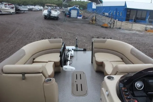 Slide: The Image of 2022 Veranda VF25F2 pontoon boat interior with beige seating, docked at a marina. - 9