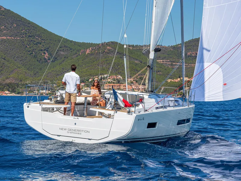 Slide: The Image of 2024 Hanse 410 sailboat cruising on blue waters with scenic coastal backdrop. - 16
