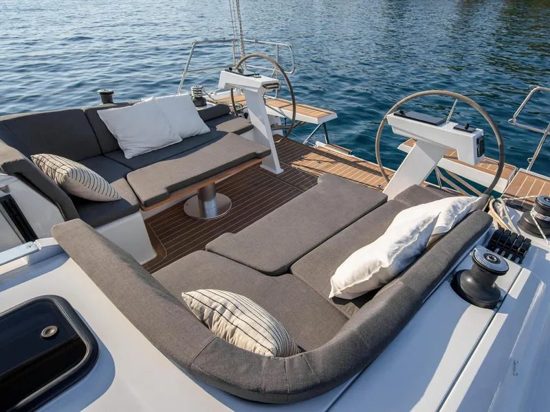 Slide: The Image of 2024 Hanse 410 yacht deck with cushioned seating and ocean view. - 6