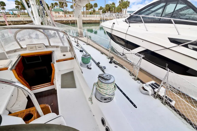 Slide: The Image of 1989 Concordia 52 sailboat deck view with winches and cockpit, docked beside another boat. - 13