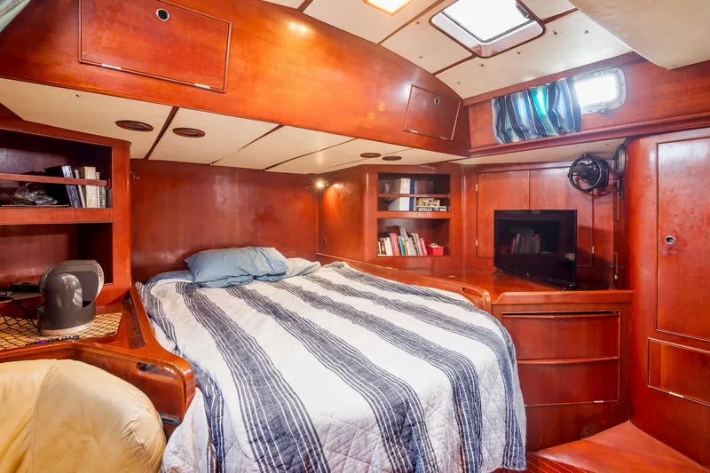 Slide: The Image of Luxurious cabin interior of a 1989 Concordia 52 yacht with a cozy bed and wooden finish. - 21