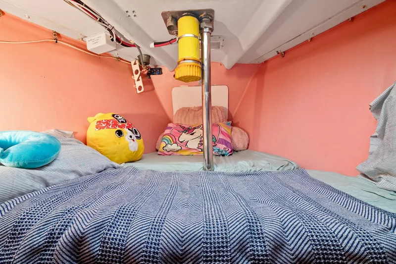 Slide: The Image of Cozy cabin bed in a 1989 Concordia 52 sailboat with colorful pillows and pink walls. - 22