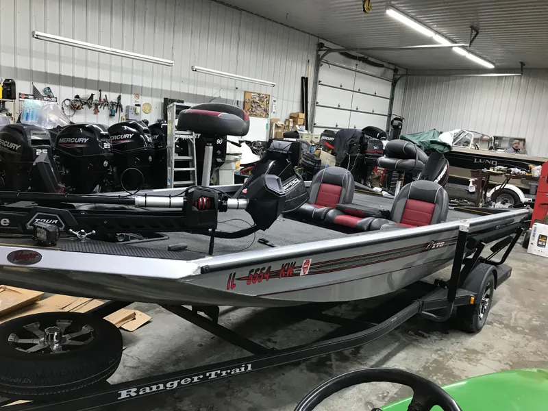 Slide: The Image of 2018 Ranger RT178 boat in a garage, featuring red and gray seating. - 19