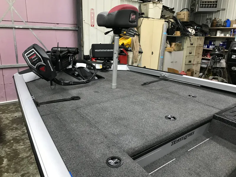 Slide: The Image of 2018 Ranger RT178 boat deck with fishing seat and equipment in a garage setting. - 20