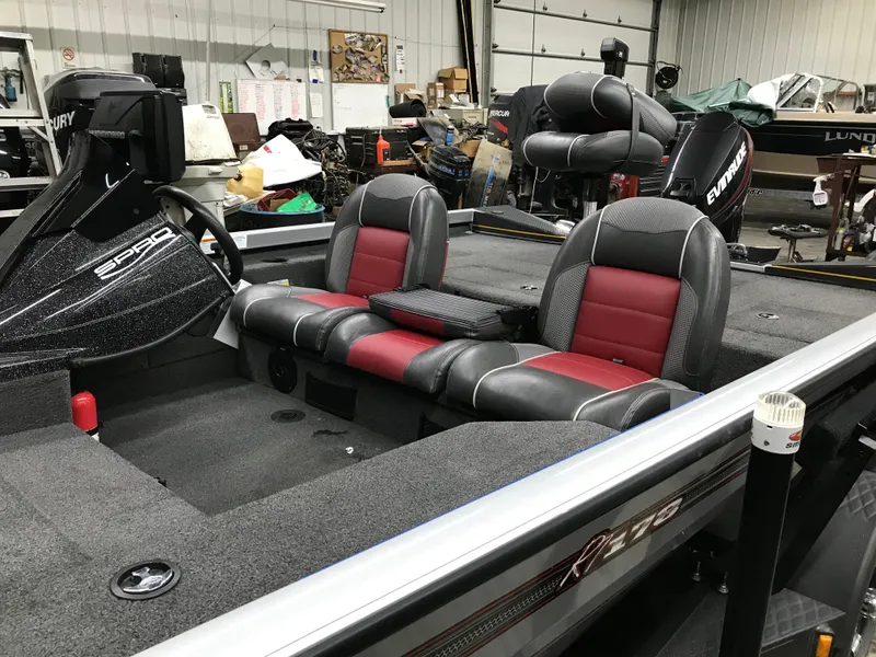 Slide: The Image of 2018 Ranger RT178 boat interior with red and black seats in a garage setting. - 22