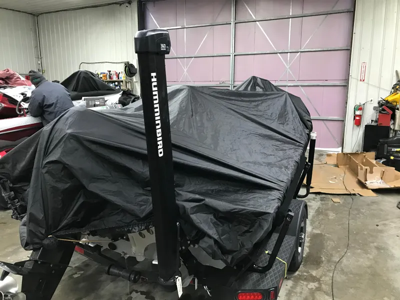 Slide: The Image of 2018 Ranger RT178 boat covered in black tarp inside a garage. - 28