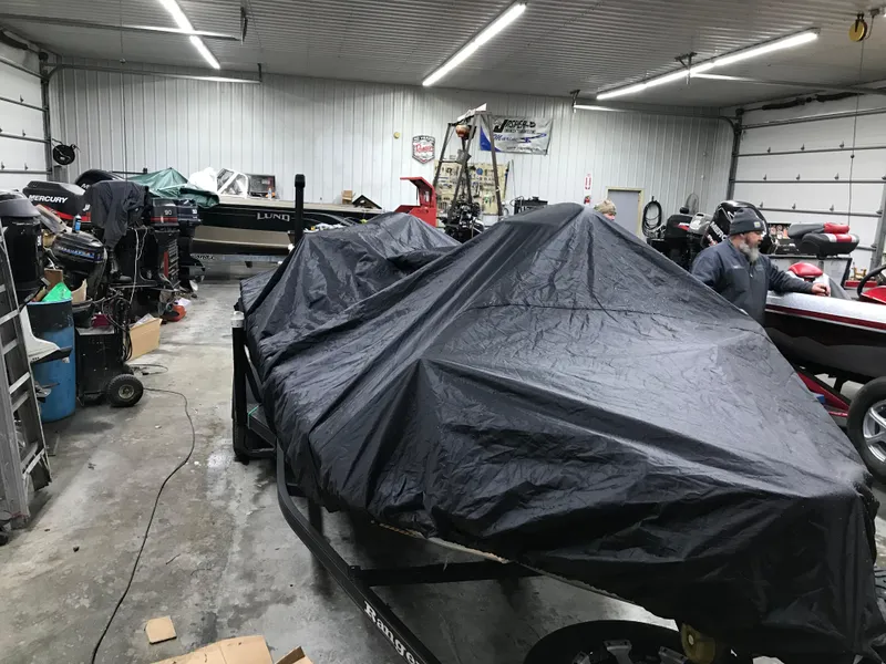 Slide: The Image of 2018 Ranger RT178 boat covered in a garage with various equipment and tools. - 30
